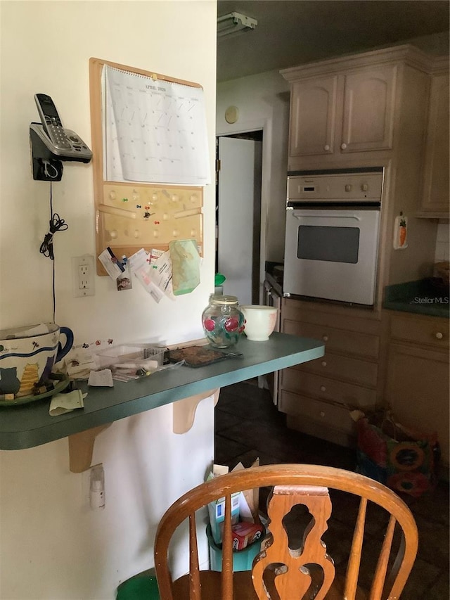 385 Dolphin Ave SE, Saint Petersburg, FL 33705 - kitchen with white oven, dark countertops, and a kitchen breakfast bar