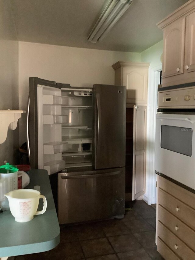 385 Dolphin Ave SE, Saint Petersburg, FL 33705 - kitchen with freestanding refrigerator, oven, and dark tile patterned floors