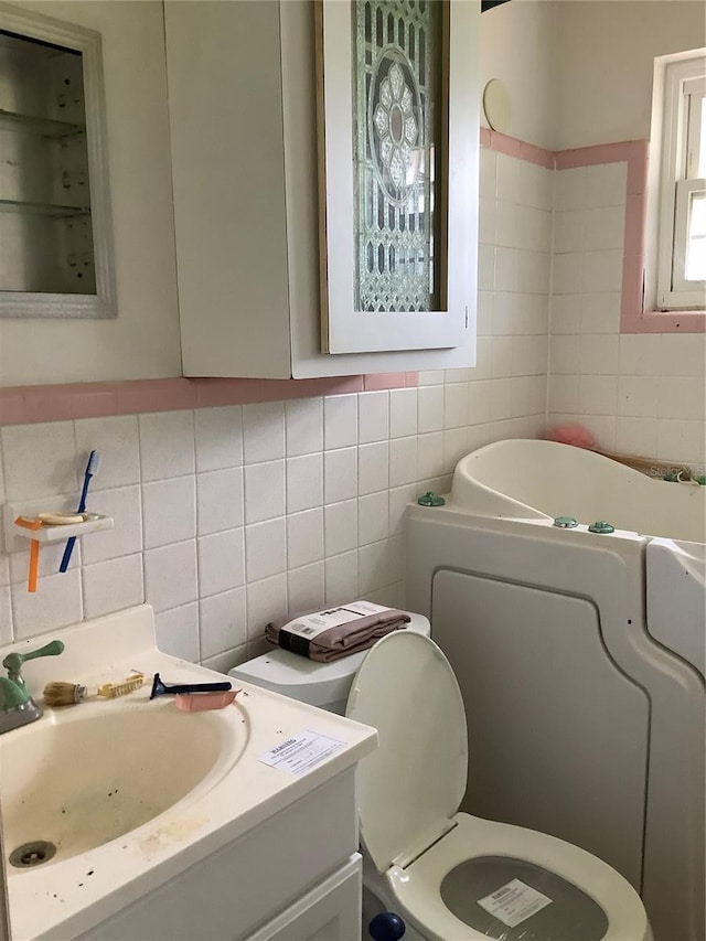 bathroom with tile walls, backsplash, toilet, and vanity