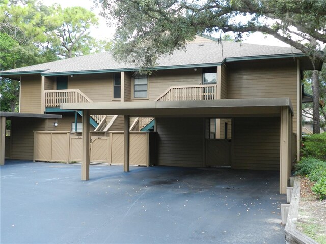 rear view of house with a carport and a balcony