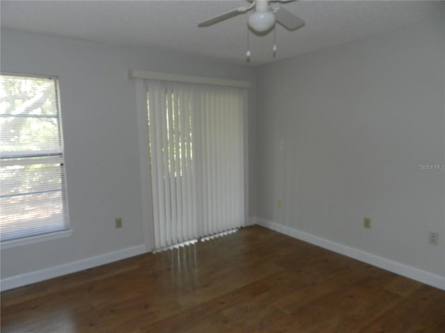 empty room with ceiling fan, baseboards, and wood finished floors