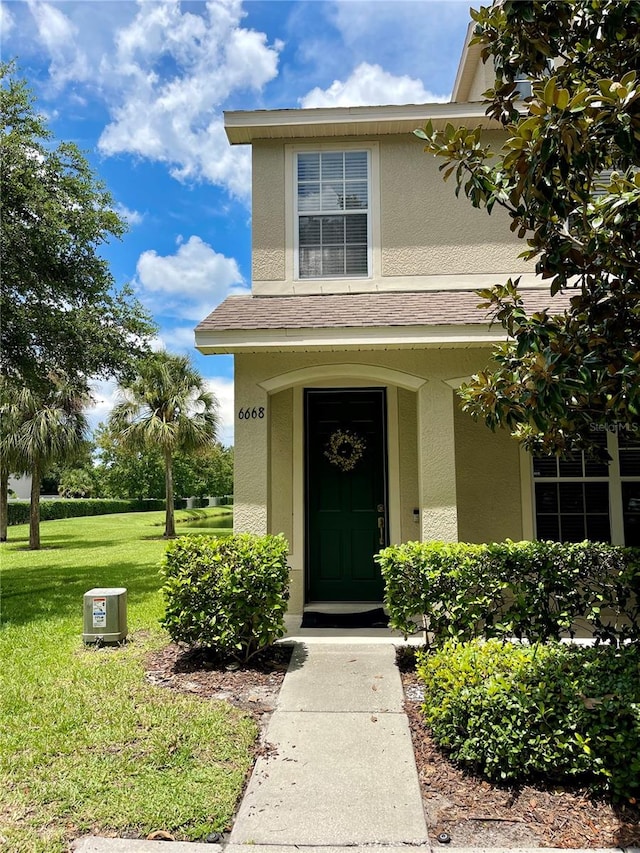 doorway to property featuring a lawn