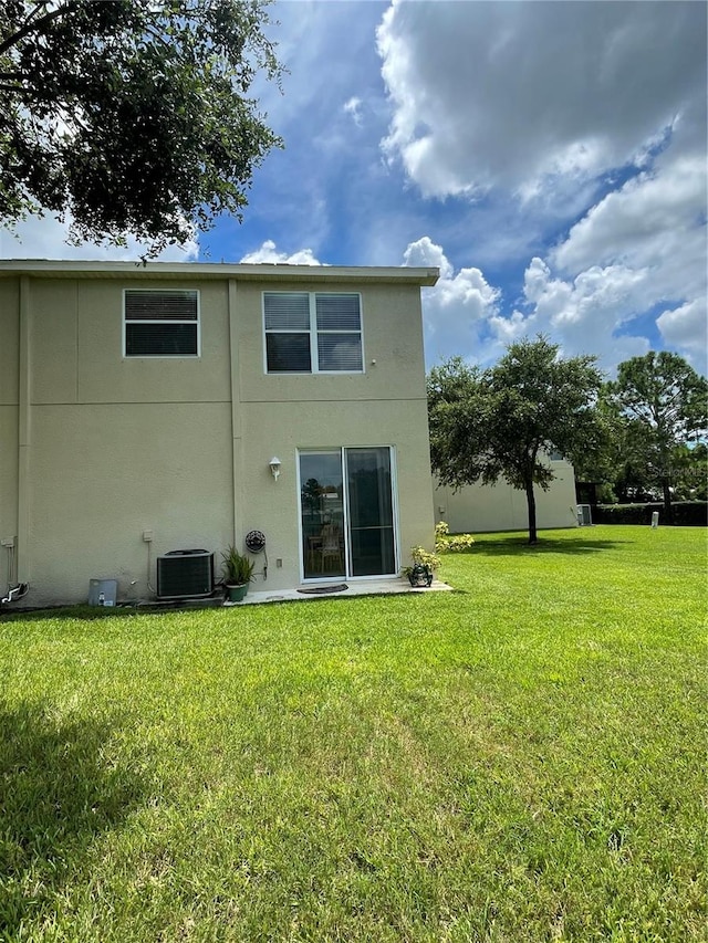 back of property featuring a yard and cooling unit