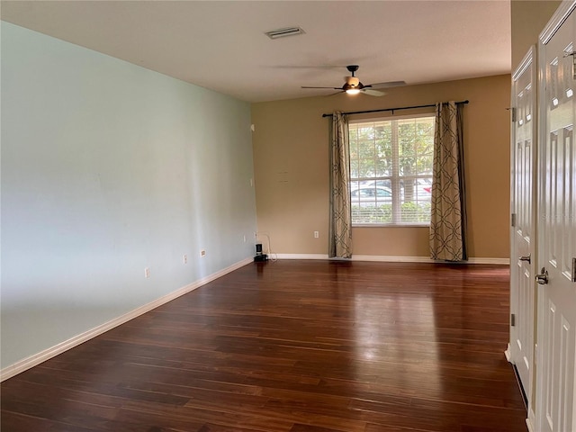 spare room featuring ceiling fan and dark wood-type flooring