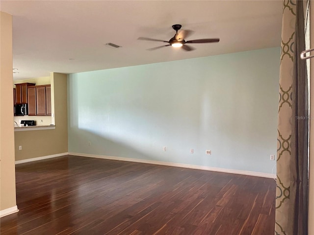 unfurnished living room featuring dark hardwood / wood-style floors and ceiling fan