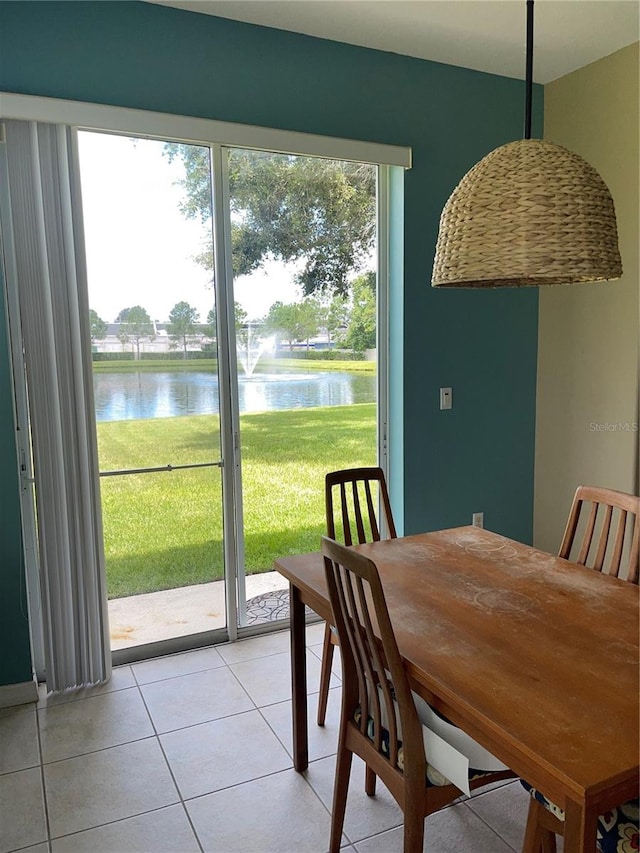 dining room with a water view and light tile patterned floors