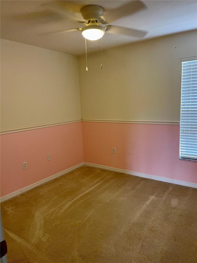 carpeted spare room featuring ceiling fan