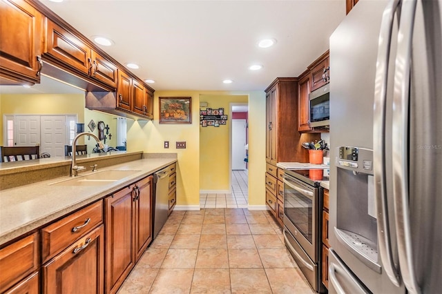 kitchen with appliances with stainless steel finishes, sink, and light tile patterned floors