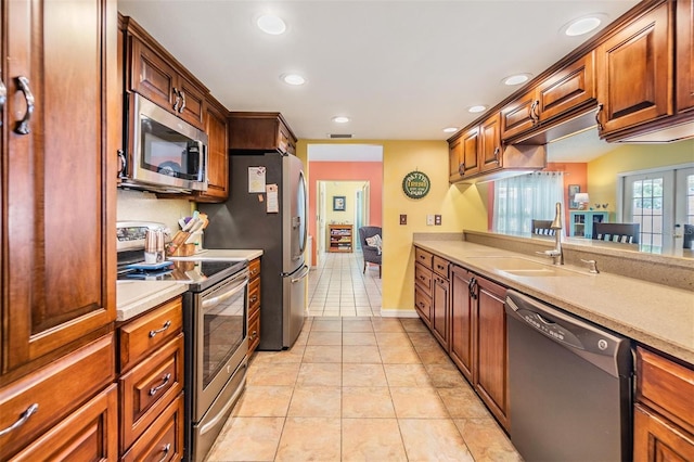 kitchen with sink, appliances with stainless steel finishes, and light tile patterned floors