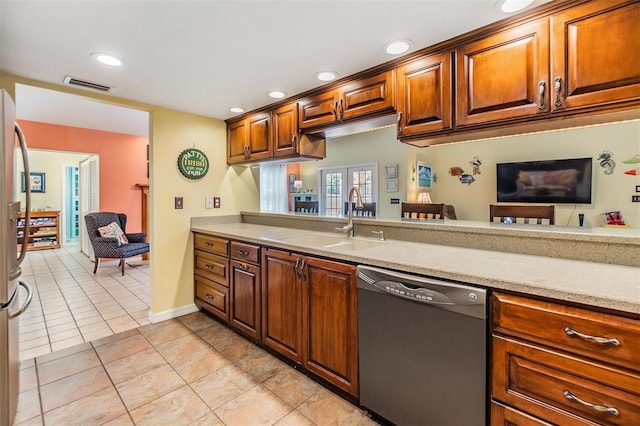 kitchen featuring sink, dishwashing machine, and light tile patterned floors