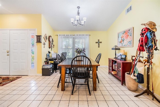 tiled dining space featuring a chandelier and lofted ceiling