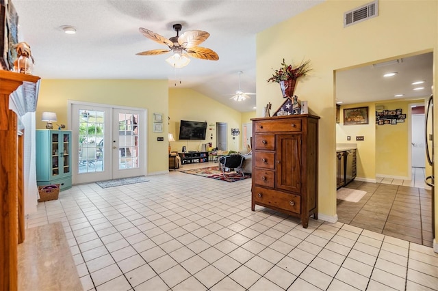 interior space with lofted ceiling, light tile patterned floors, french doors, and ceiling fan