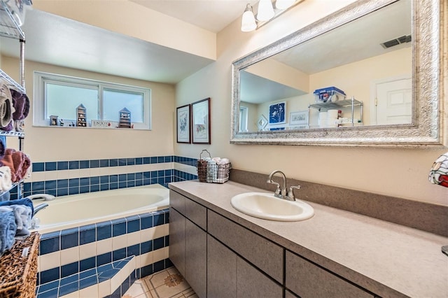 bathroom featuring vanity, tiled bath, and tile patterned flooring