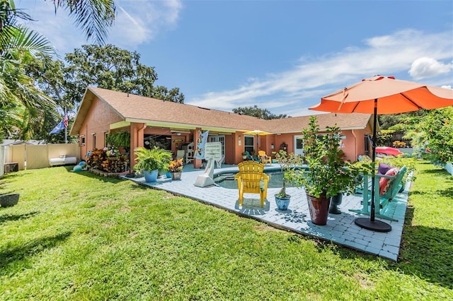 rear view of property featuring a patio and a lawn