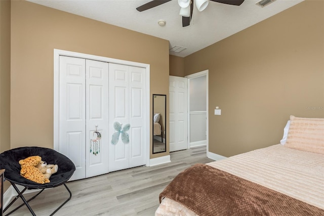 bedroom featuring ceiling fan, light hardwood / wood-style floors, and a closet