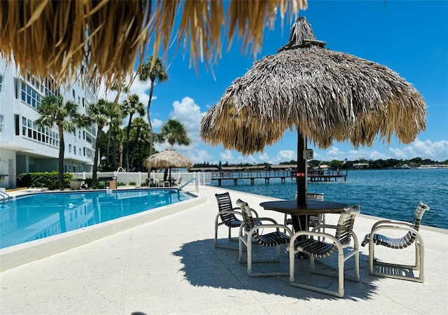 view of pool with a water view and a patio area