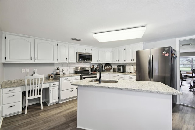 kitchen with a kitchen island with sink, dark hardwood / wood-style flooring, white cabinets, and appliances with stainless steel finishes