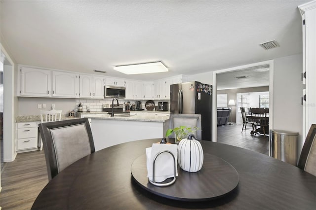 dining space featuring dark hardwood / wood-style flooring, a textured ceiling, and sink