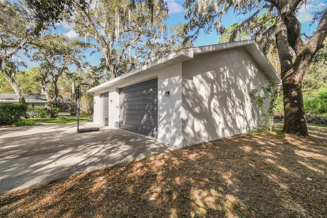 view of property exterior with a garage and an outbuilding