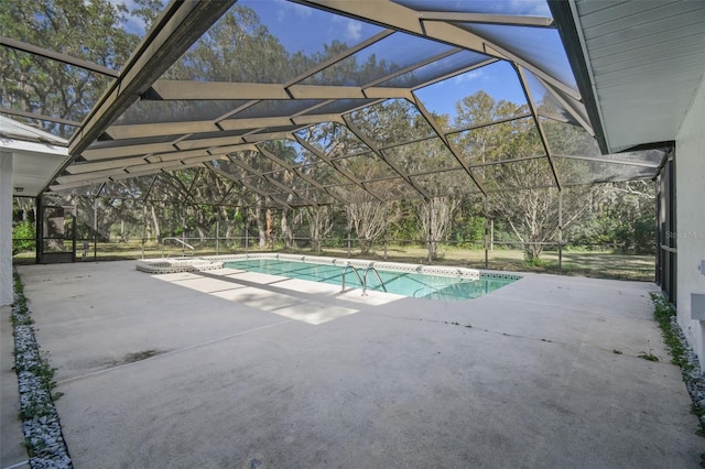 view of pool with glass enclosure and a patio