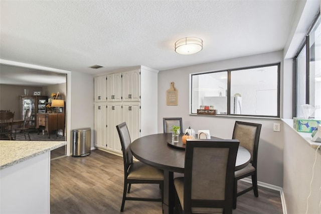 dining room featuring dark hardwood / wood-style floors and a textured ceiling