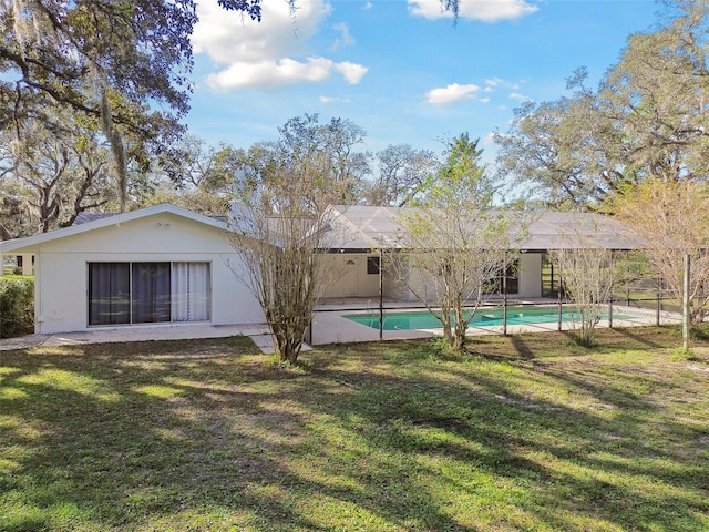 back of property with a lanai and a lawn