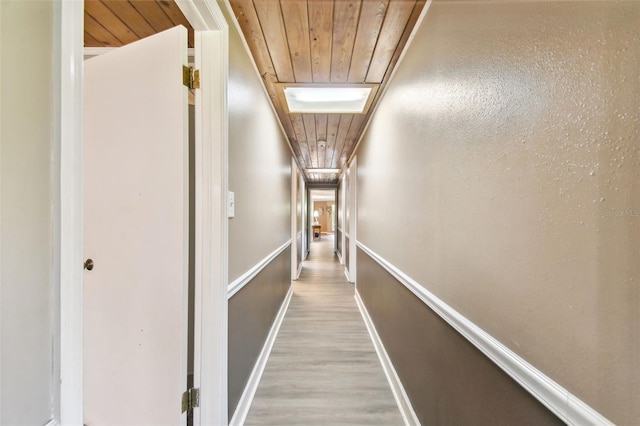 hall with wood ceiling and light wood-type flooring