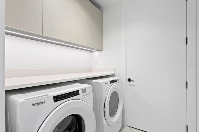 washroom with cabinet space and washer and clothes dryer
