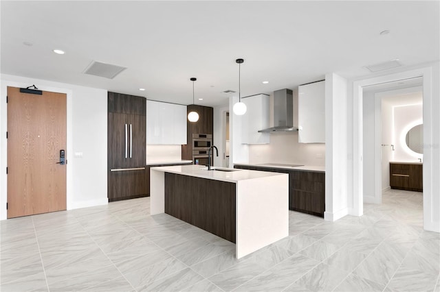 kitchen featuring paneled refrigerator, modern cabinets, wall chimney exhaust hood, and light countertops