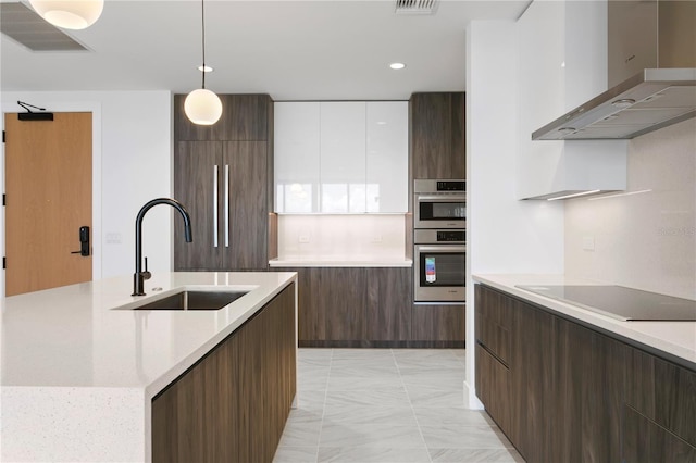 kitchen featuring white cabinets, wall chimney range hood, sink, hanging light fixtures, and black electric cooktop