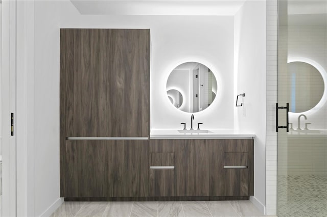 full bath featuring vanity, baseboards, marble finish floor, and a stall shower