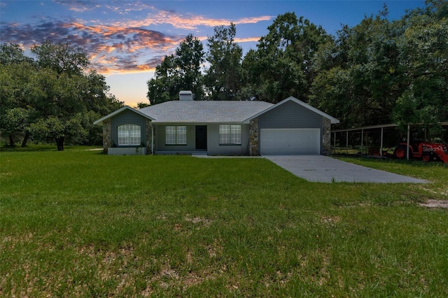 ranch-style home featuring a garage and a lawn