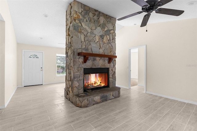 unfurnished living room featuring a stone fireplace, a textured ceiling, ceiling fan, and lofted ceiling