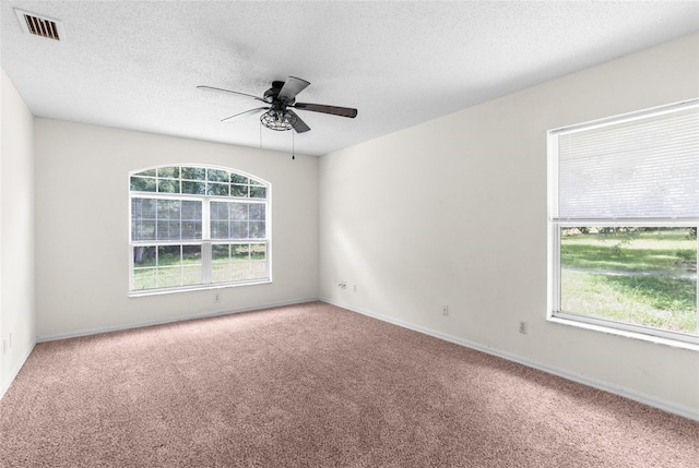 carpeted spare room with a textured ceiling and ceiling fan