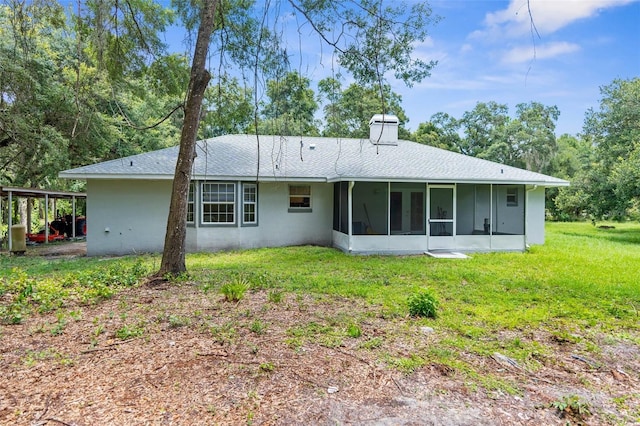 back of house with a sunroom and a lawn