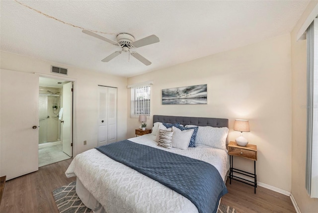 bedroom featuring hardwood / wood-style flooring, connected bathroom, and a textured ceiling