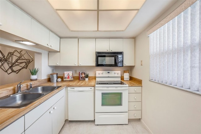 kitchen featuring butcher block countertops, sink, white appliances, light tile patterned floors, and white cabinets