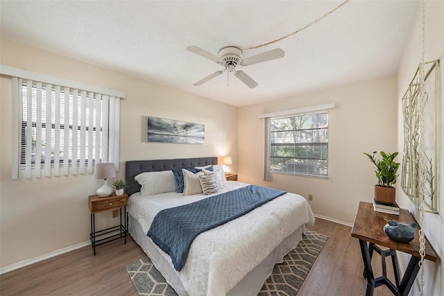 bedroom featuring wood-type flooring, a textured ceiling, and ceiling fan