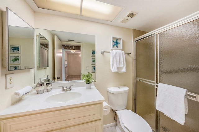 bathroom with vanity, a shower with shower door, and toilet