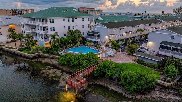 aerial view at dusk featuring a water view