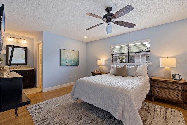 bedroom featuring a textured ceiling, light hardwood / wood-style flooring, and ceiling fan