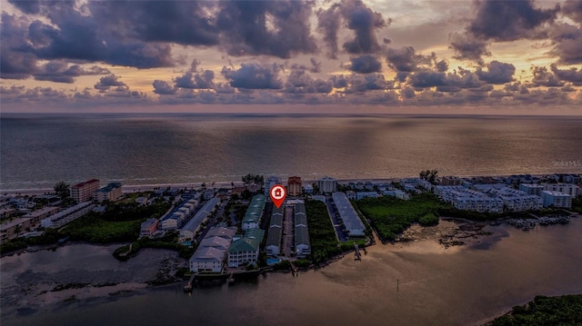 aerial view at dusk featuring a water view