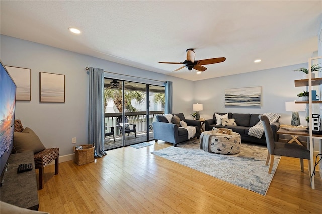 living room featuring light hardwood / wood-style flooring and ceiling fan