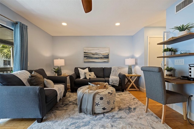 living room featuring hardwood / wood-style flooring and ceiling fan