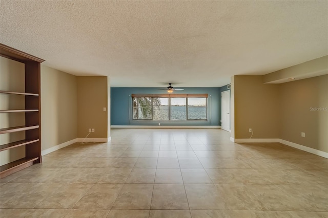 spare room with ceiling fan, a textured ceiling, and light tile patterned flooring