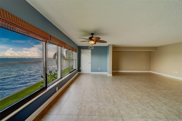 unfurnished sunroom featuring a water view and ceiling fan