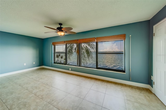 unfurnished room with light tile patterned floors, a textured ceiling, and ceiling fan