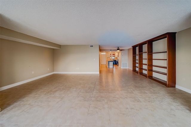 unfurnished room featuring ceiling fan and a textured ceiling