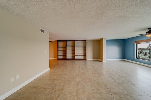 empty room featuring a textured ceiling and ceiling fan