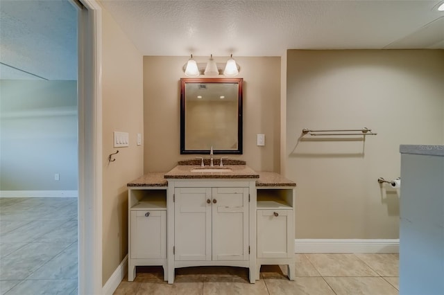 bathroom featuring tile patterned flooring, vanity, and a textured ceiling